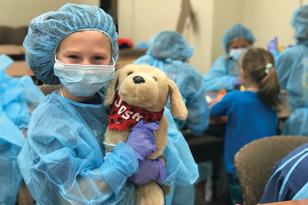 girl dressed as a surgeon with a stuffed animal