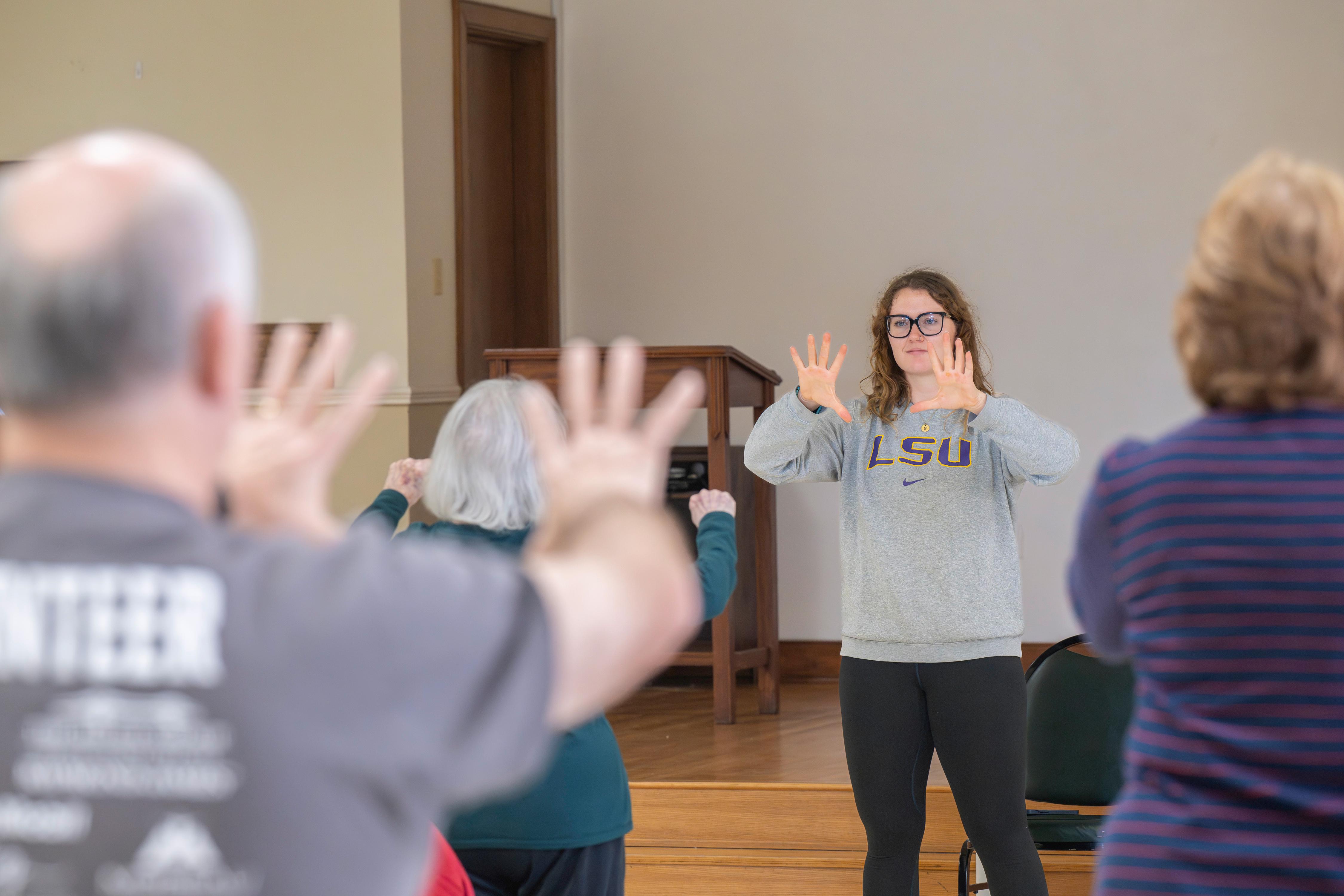Grad student Taylor Gauss leads a modified tai chi class