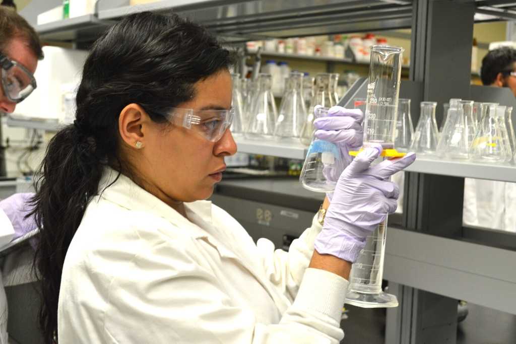 Researcher holds glass vial