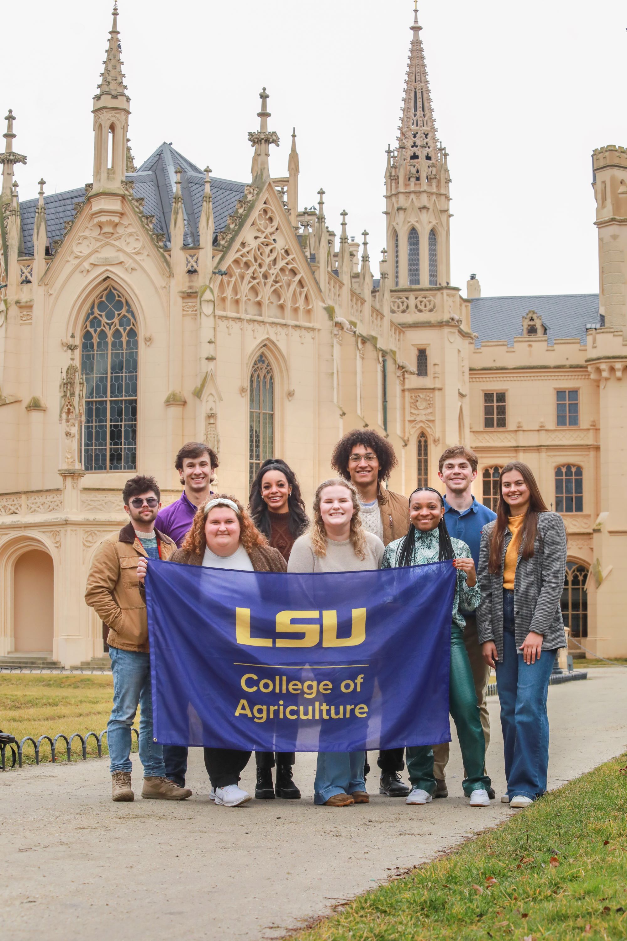 Students hold LSU flag in front of castle