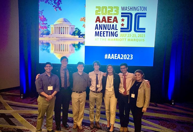 Seven LSU College of Ag students in front of the convention's banner 