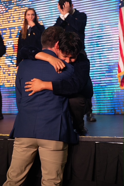 Nick Adams embraces student after winning state office election.