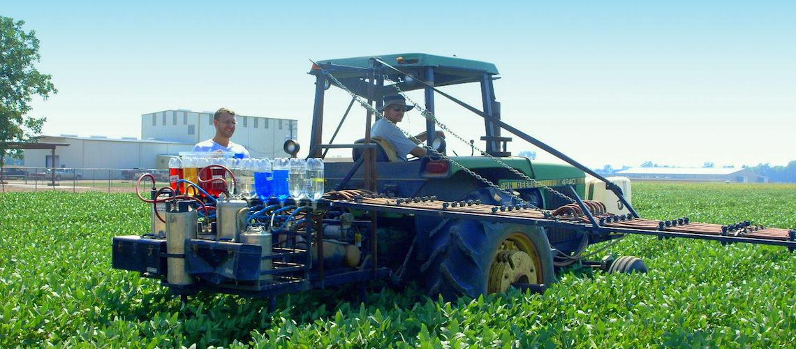 Tractor sprays soybean field