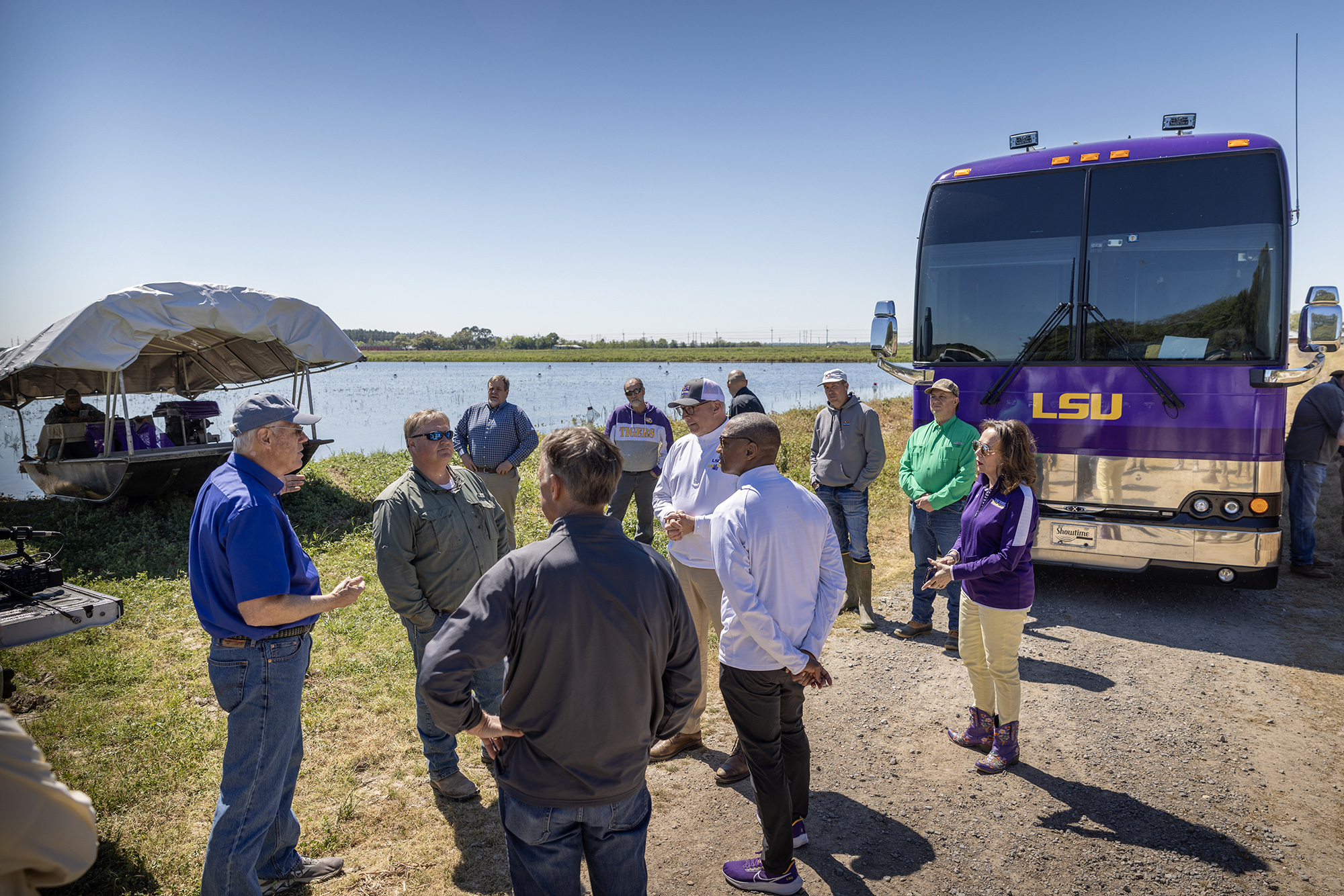  President Tate in conversation with group at crawfish pond with bus in background