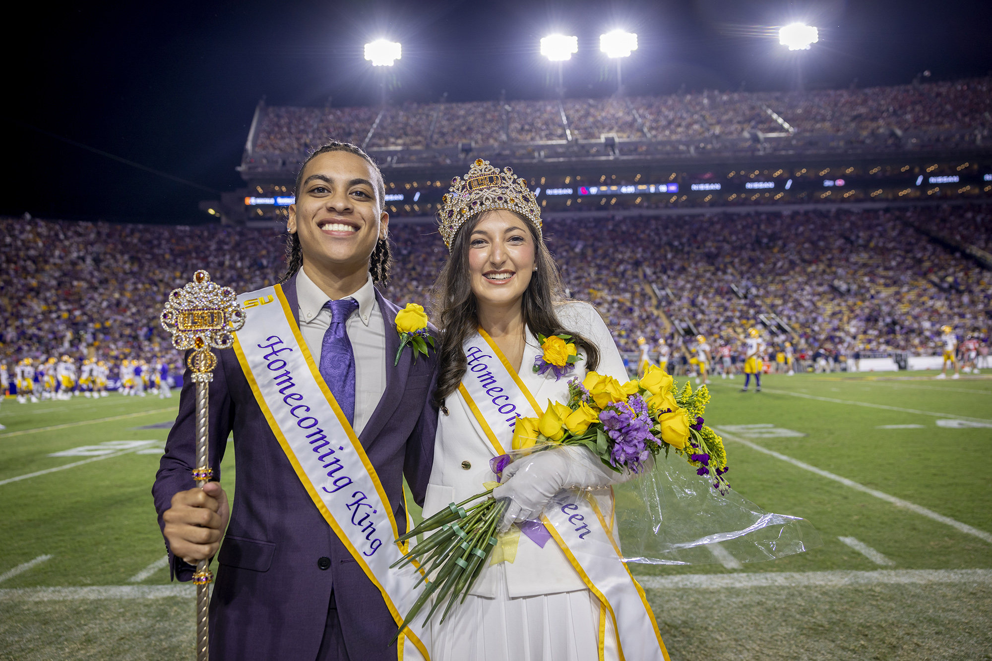 2024 Homecoming king and queen on football field sideline