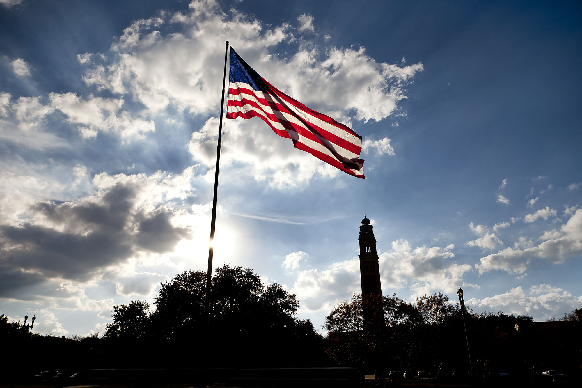 American flag on LSU campus with Memorial Tower in the background