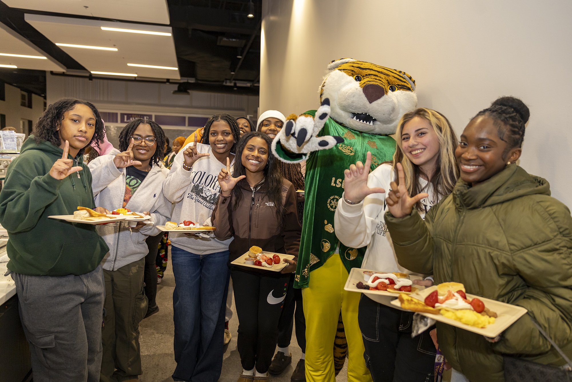 Group of students takes a selfie with mascot Mike during the President's Late Night Breakfast