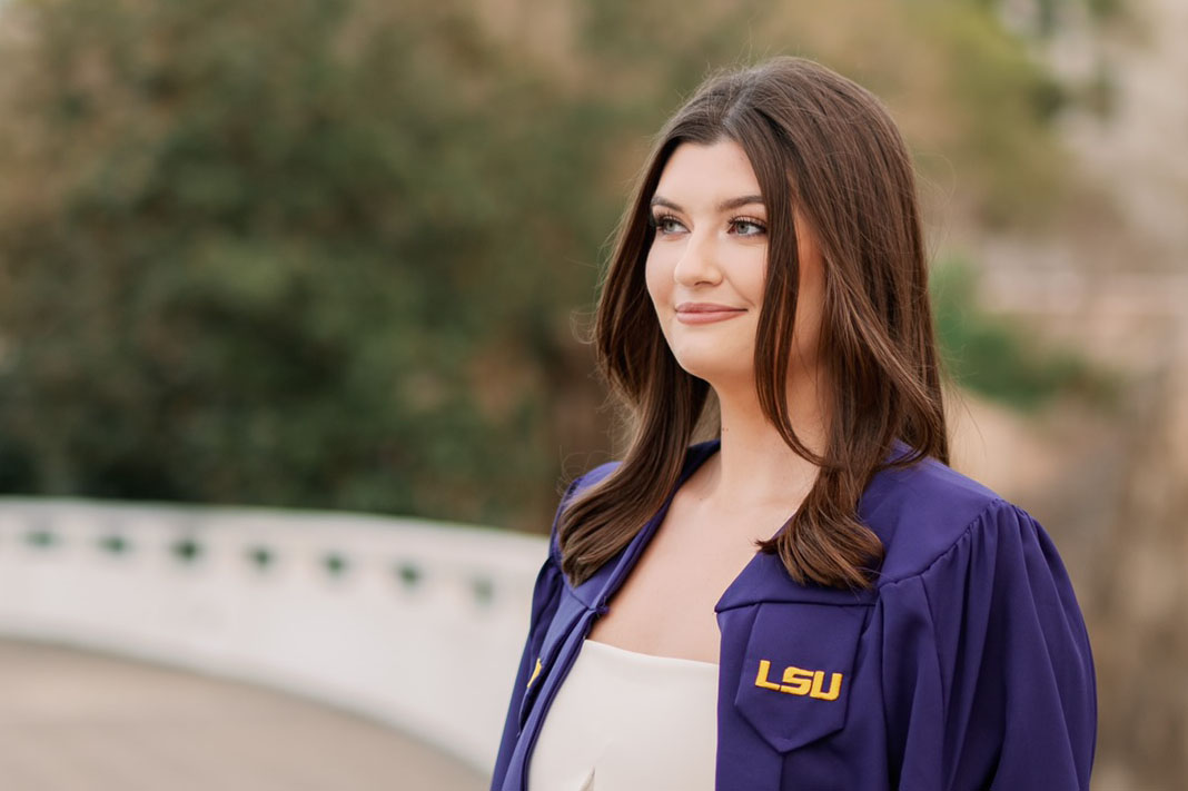 Madison Menou in graduation gown on LSU campus