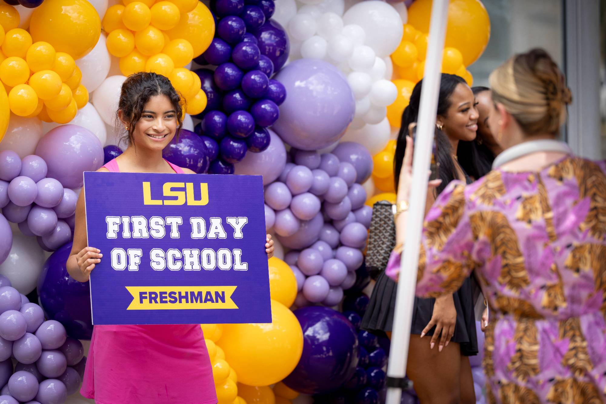 LSU student holds a first day of school sign