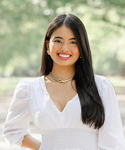 Melissa's headshot wearing a white dress taken outdoors.