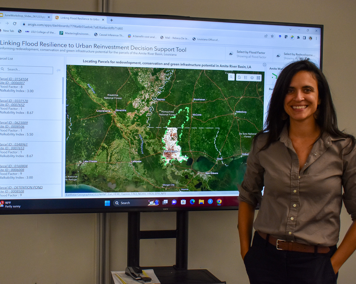 a woman stands in front of a digital screen with a map on it