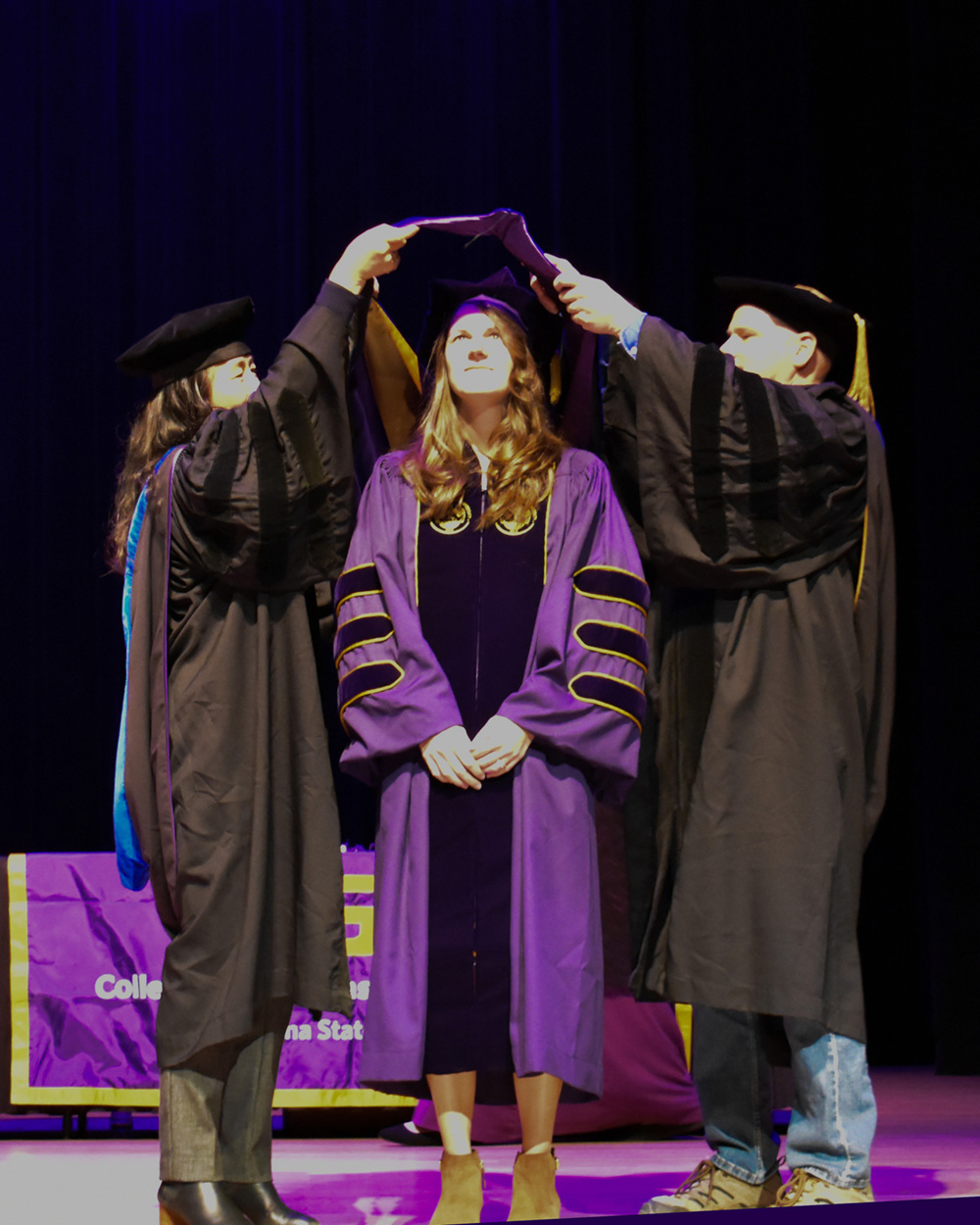 A student receiving a Masters hood