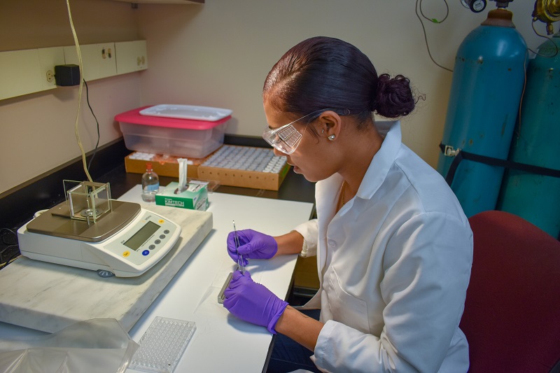 student researcher using a scale