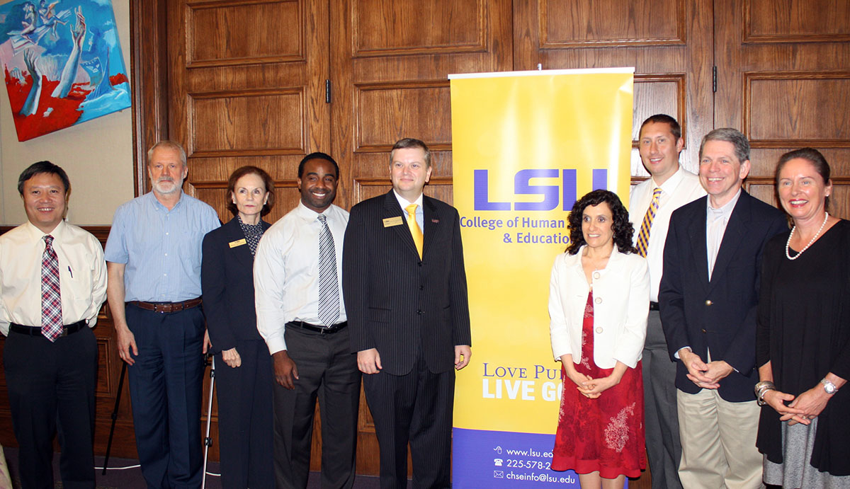 presenters and students pose at the CTP Internationalization Symposium in front of an LSU bannerstand
