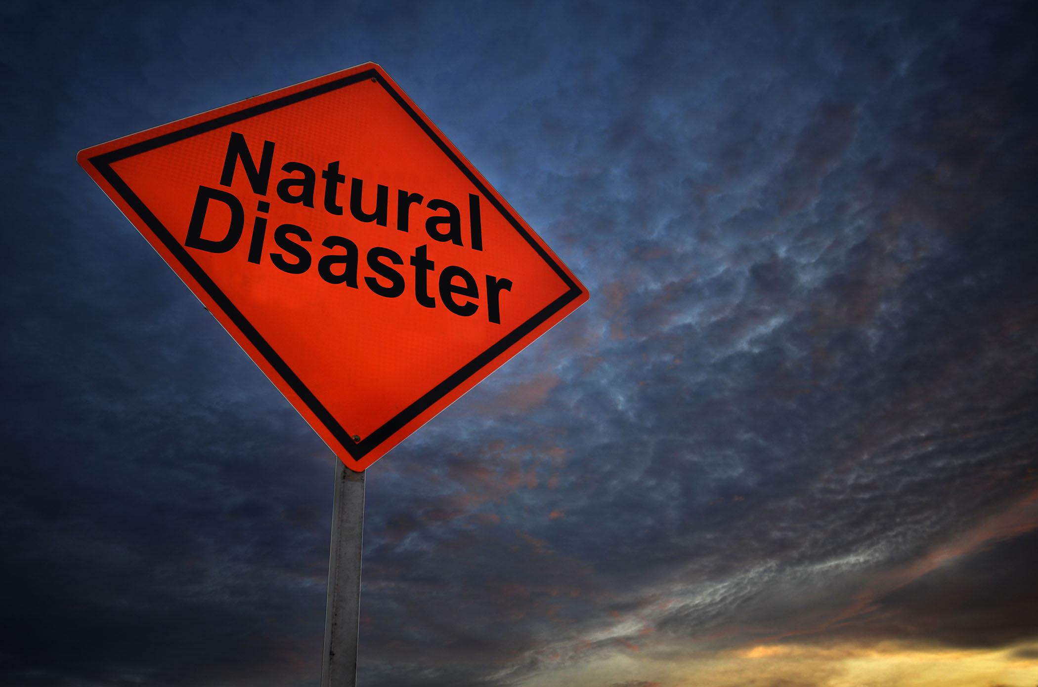 road sign that says Natural disaster against a stormy sky