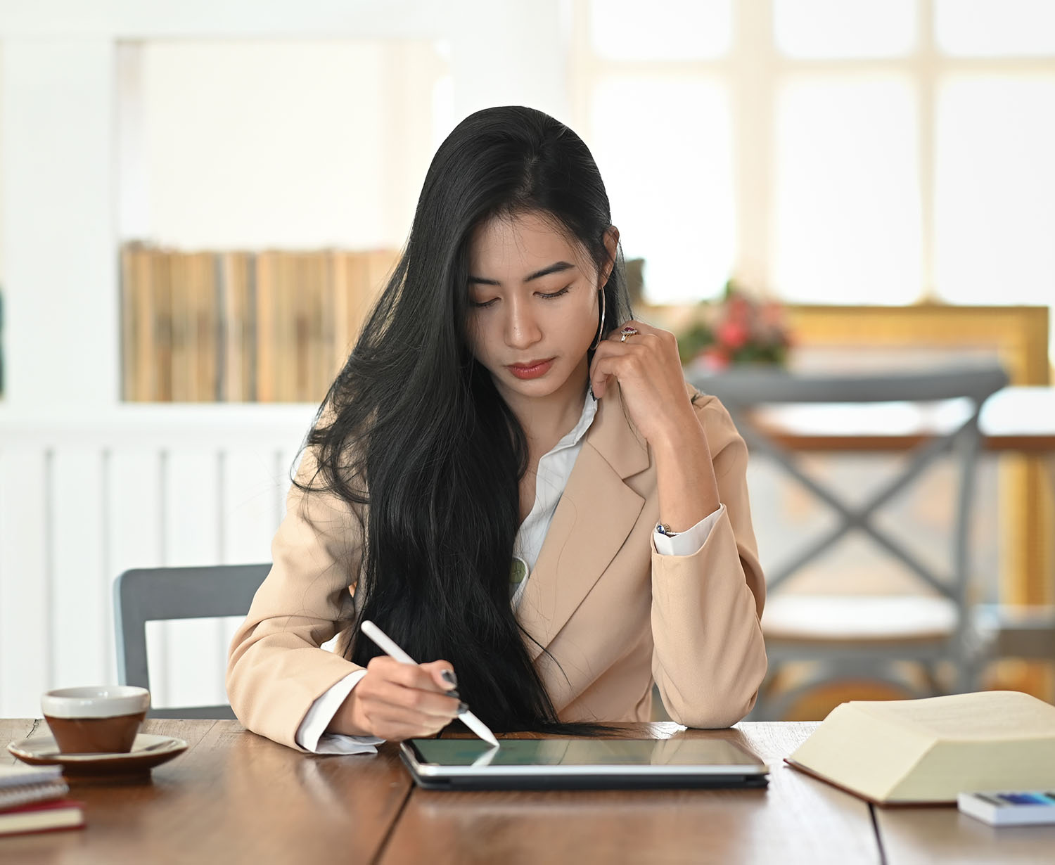 Asian woman writing on a tablet