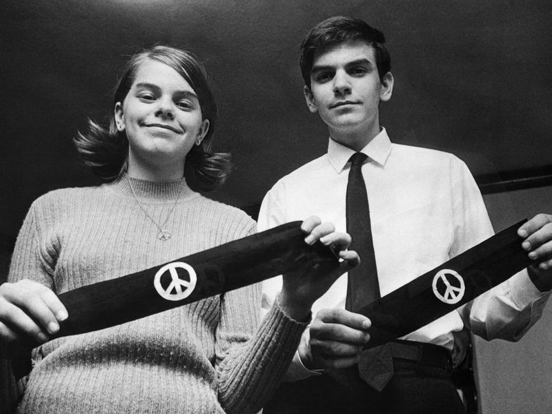black and white photo of Mary Beth and John Tinker holding bandanas with peace symbols 