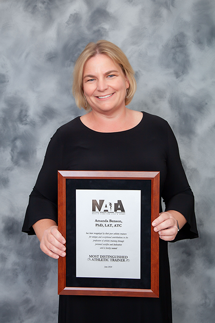 Amanda Benson, PhD, LAT, ATC, holding her NATA "Most Distinguished Athletic Trainer" Award