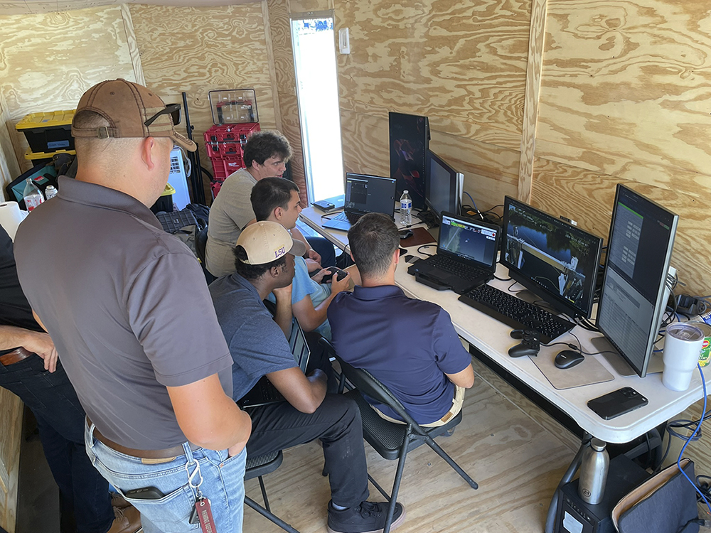 LSU students and Chance employees look at computers together