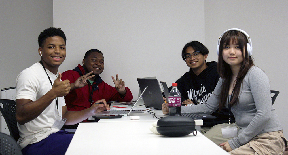 Students at a table with thumbs up