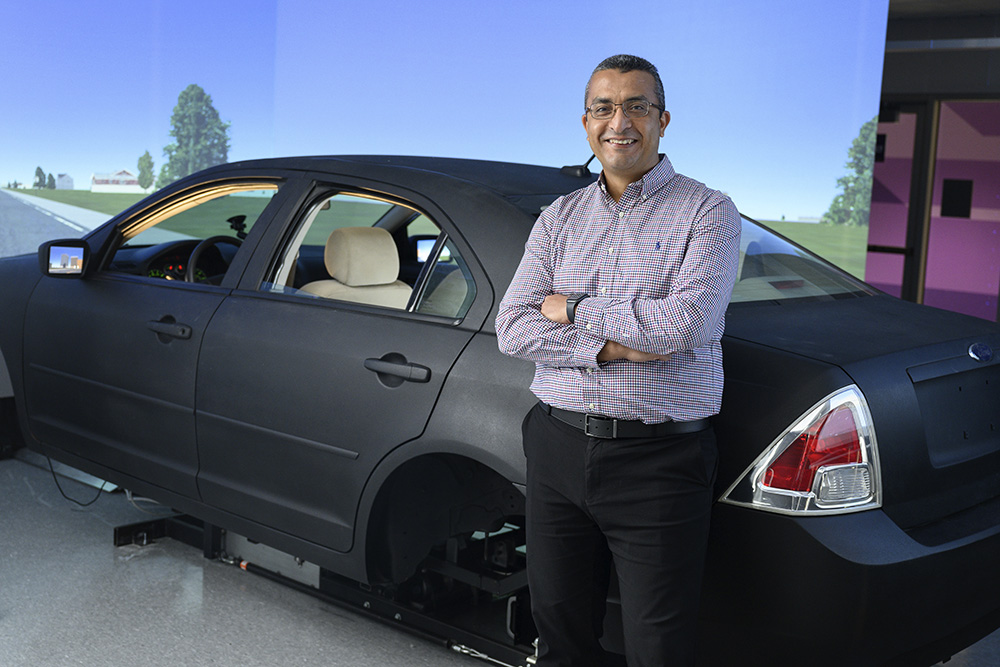 Hany Hassan in front of driving simulator