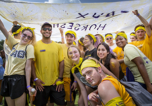 Group of students in yellow smiling. 