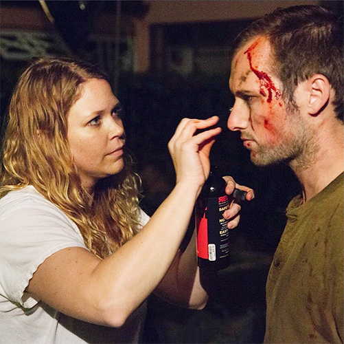 Lauren Wilde applying makeup to actor