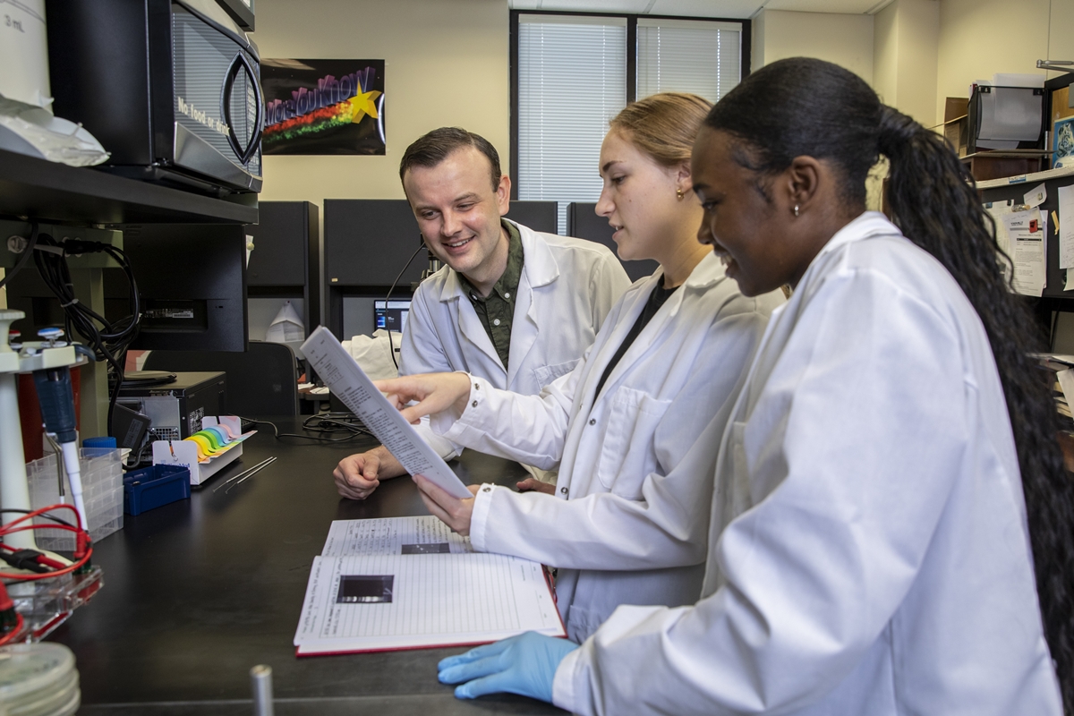 Biological Sciences Associate Professor Dr. David J. Vinyard with his students in the lab.