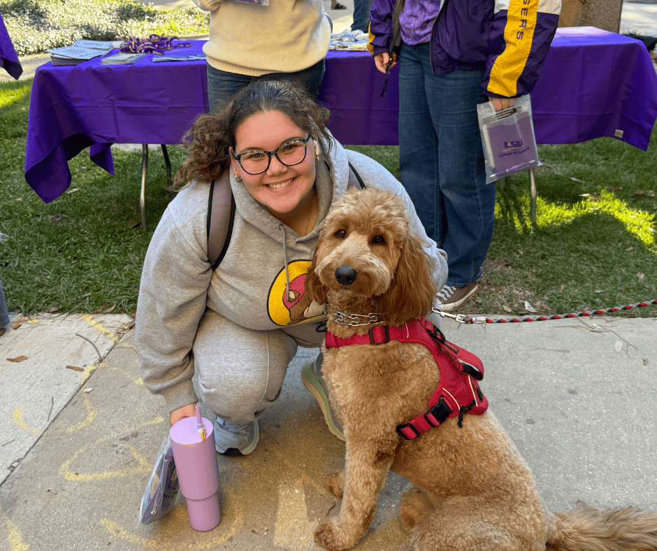 A student petting a therapy dog. 