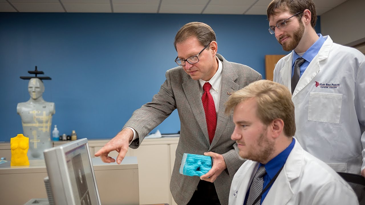 Professor Wayne Newhauser from LSU working with students in his lab.